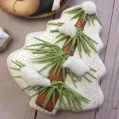 two decorated cookies sitting on top of a white plate next to other food and utensils