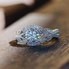 a diamond ring sitting on top of a wooden table