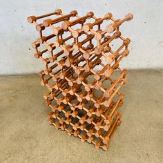 a stack of wooden wine racks sitting on top of a cement floor next to a wall