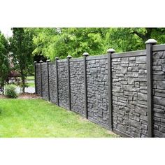 a stone fence in the middle of a yard