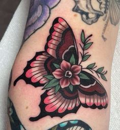 a close up of a person's arm with tattoos on it and a butterfly