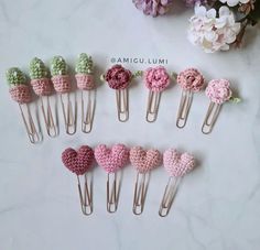 several pieces of crocheted hair clips with flowers in them on a marble surface