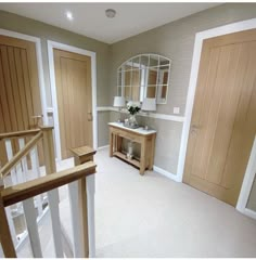 an empty room with two doors and a mirror on the wall, next to a stair case