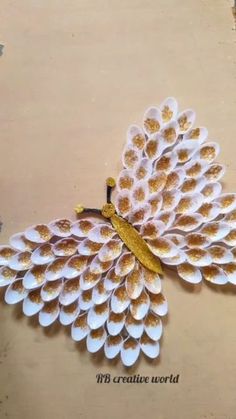 a paper peacock made out of white and gold feathers