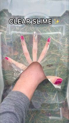 a person's hand with pink and white nails in a clear plastic bag that says clear slime