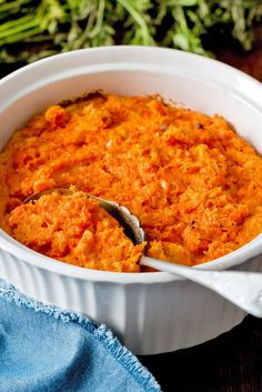 a white bowl filled with mashed carrots on top of a wooden table