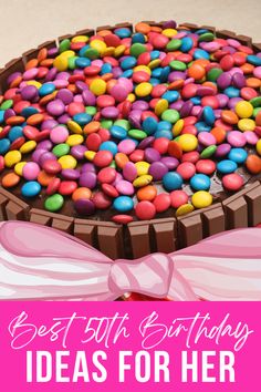 a birthday cake with chocolate and candy toppings in the shape of a heart on top