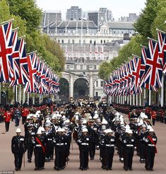 a group of men in uniform marching down the street with union jack flags on them