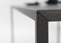 the edge of a wooden table with metal legs