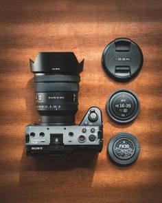 a camera and lens cap sitting on top of a wooden table next to each other