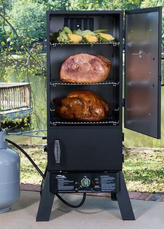 an outdoor bbq grill with meat and vegetables on the burner, next to a propane tank