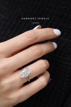 a woman's hand with a diamond ring on her finger and the words harmony jewels