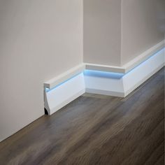 an empty room with white walls and wood flooring is illuminated by blue leds