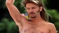 a man with long hair and no shirt holding a frisbee in his hand