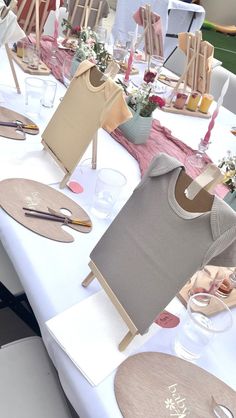 the table is set up with wooden clothes and place settings