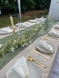 the table is set with white plates and silverware