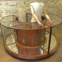 a mannequin sitting on top of a wooden table