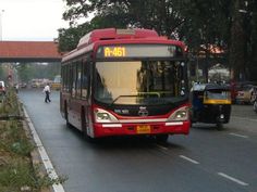 a red bus is driving down the street