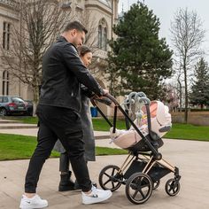 a man pushing a stroller with a baby in it