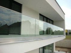 a balcony with glass balconies and sliding doors on the side of a building