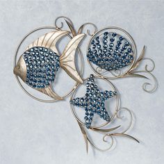 three metal wall art pieces with blue beads in the shape of fish and starfish