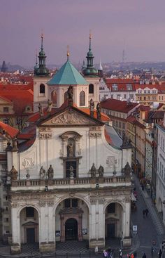 an aerial view of a large building in the middle of a city with many people walking around it