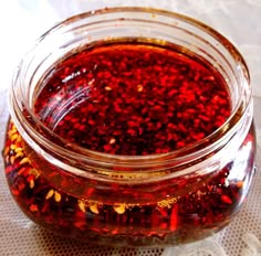 a jar filled with red liquid sitting on top of a table