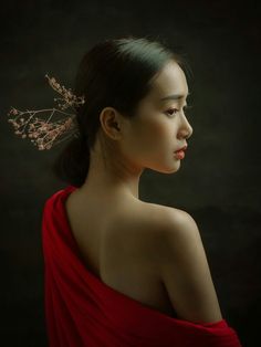 a woman in a red dress wearing a hair comb with flowers on it's head