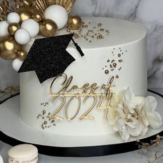 a graduation cake decorated with gold and white decorations