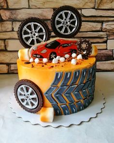 a birthday cake decorated to look like a car with wheels and tires on the side