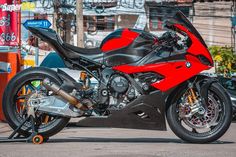 a red and black motorcycle parked on the street