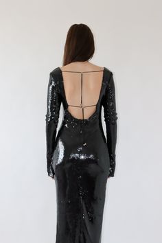 the back of a woman wearing a black sequin dress