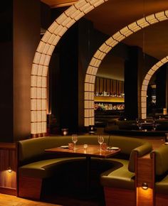 a dimly lit restaurant with curved booths and wooden tables