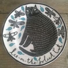 a plate with an image of a black cat on it's side and the words lee - on the platter written below