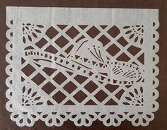 a piece of paper cut out to look like a bird sitting on a table cloth