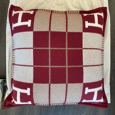 a red and white pillow sitting on top of a wooden floor