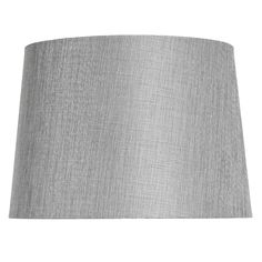 Illuminate your space with modern charm Complete the look of any table lamp with this chic and versatile light grey shade. Constructed with a fabric material, it effortlessly blends into any decor style, adding a touch of contemporary elegance. Designed in a taper shape, this shade not only diffuses the light beautifully but also creates a cozy and inviting ambiance. Its neutral grey tone allows it to seamlessly complement a variety of lamp bases, making it a must-have addition to any room. Shade Type: Spider (requires harp and finial). Shade Material: 100% polyester shade with a styrene lining. Care: Wipe with soft, dry cloth. To protect finish, do not apply abrasives or household cleaners. 14in. L × 10in. W × 12in. H. | Light Grey Table Lamp Shade, Linen Table Lamp Shade, Silver Lamp, Gray Table, Grey Table Lamps, Grey Table, Table Lamp Shades, Upper And Lowercase Letters, Grey Material, Household Cleaners