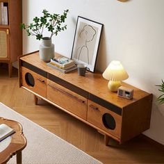 a living room with a wooden entertainment center and bookshelf in the corner next to a lamp