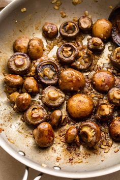 cooked mushrooms in a pan with seasoning and spices on the side, ready to be eaten