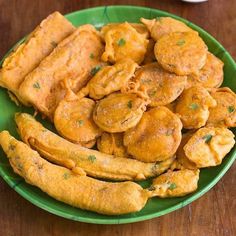 a green plate filled with fried food on top of a wooden table