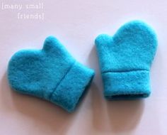 two blue mittens sitting on top of a white table