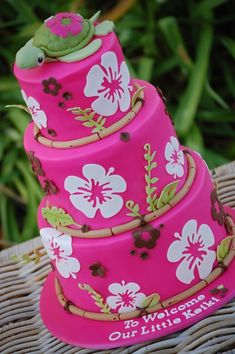 a three tiered pink cake with flowers on it