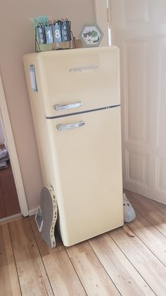 an old fashioned refrigerator sitting in the corner of a room next to a wooden floor