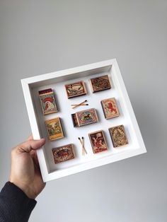 a person holding up a box with different types of matches and matchesticks in it