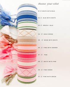 a stack of multicolored bracelets sitting on top of each other next to a white wall