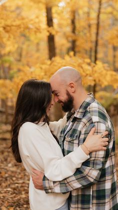 an engaged couple embrace in the woods during their fall engagement photo session at stone mountain state park