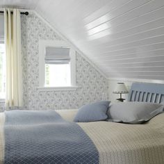 a bed sitting under a window in a bedroom