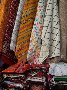 many different colored rugs and blankets on display