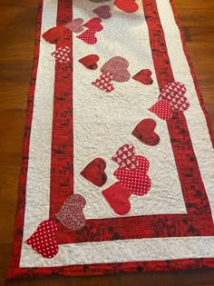 a red and white table runner with hearts on it