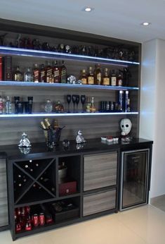 a bar with liquor bottles and glasses on the top shelf, along with other items